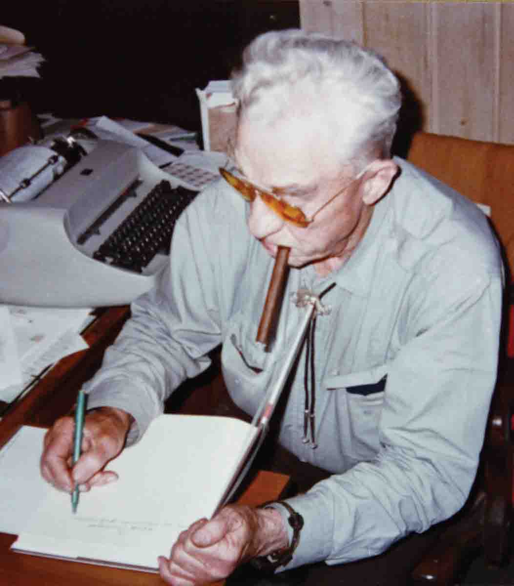 Elmer Keith, with his ever-present cigar, autographing one of his books.